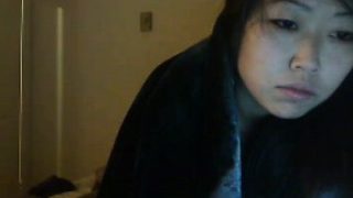 Young Asian brunette FredFreeload lies in bed to participat