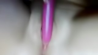 Bored girl plays with a pink dildo