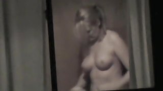 Topless bimbo is kinkily voyeured through the window