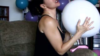 Brunette slut teasing while blowing balloons