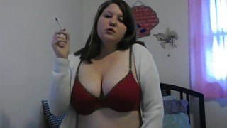 Busty girl smokes and gives a peak