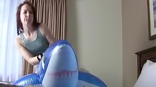 Chick enjoys a solo game with a big blow up fish toy