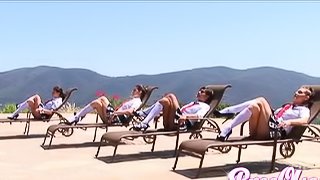 Four beautiful ladies in plaid skirts and knee high socks tan outdoors