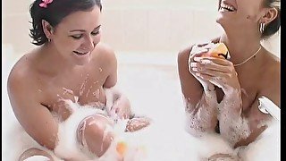 Tattooed lesbians play with soapy water before toy fucking in close up