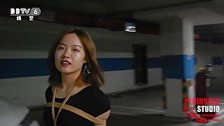 Young Chinese Girl Walks Around Carpark Tied Up