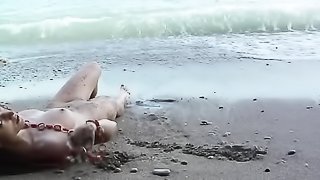 Babe lies on sand and poses sexily on beach rocks stark naked!