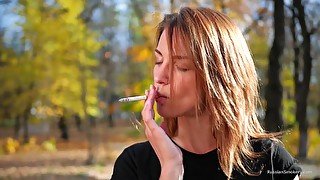 Sasha Is Smoking Two Cigarettes One By One In The Autumn Park