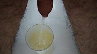 Filling up a cup with piss in slow motion