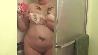 Tattooed fat chick strips to wash her tits and cunt in the shower