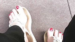 Sandals teasing outdoor with red toenails & toes wiggling