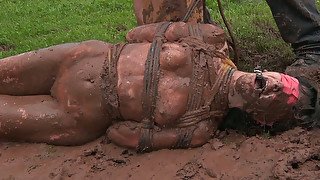 Ample dark haired whore rolls in mud under guidance of horny master