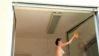 Short haired girl washes windows topless