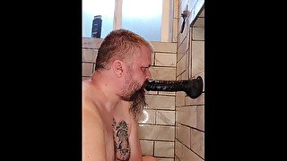 Slave practices cock sucking on dildo