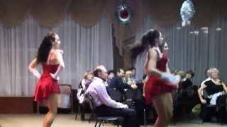 A pack of naughty girls dance around a guy sitting in a cha