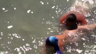 Girl sucks dick her boyfriend in the surf at a public beach