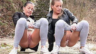 Stunning young hot girls in the park squat and piss in line