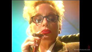 Blonde mature lady with glasses smokes a cigar and plays with her tits