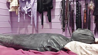 Mistress Priest puts Evie in a latex bondage bag, polishes it and has sensual fun with her slave