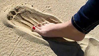 Red Toe Nails in the Beach Sand