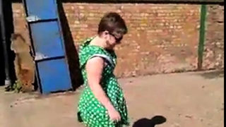 Flashing in green dress and white stilettos