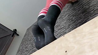 Blond girl showing her feet for the first time while working out in leggings and socks