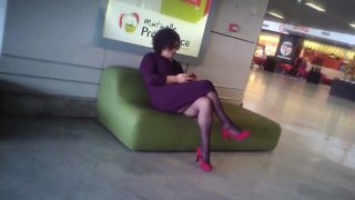 Sexy bimbo plays with her phone at the airport while being