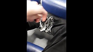 A young guy shows his legs in fashionable sneakers on the train