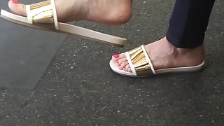 Sexy feet at London tube station, red toes dangling feet