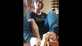 Peels a banana with her toes and takes a big bite