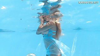 Her Body Cutting Through The Shimmering Water Of The Pool