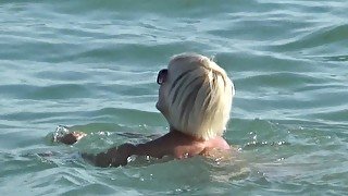 Naked blonde on a Nude beach. Masturbating and pissing.