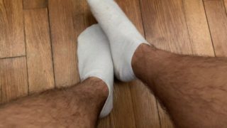 Étudiant joue avec ses pieds en chaussettes blanches