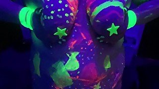 BBW girl with black light body paint touches herself with big glowing dildo