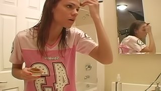 Young teen is doing make up in her bathroom using quite lots of details