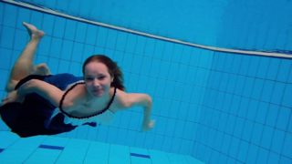 Teen girl Avenna is swimming in the pool