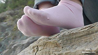 Sexy feet in pink ankle socks on the seashore