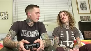 Tattooed gay guy with long dark blonde hair enjoying an awesome ass fuck